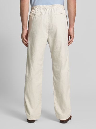 Mężczyzna nosi Leinenhose mit elastischem Bund und Eingrifftaschen von GAP, mieszanka lnu i bawełny, krój loose fit, elastyczny pas, wpuszczane kieszenie, tylne kieszenie z wypustką, kolor jasny beż, gładka faktura, Szerokość w rozmiarze M: 43 cm, Długość wewnętrzna nogawki: 80 cm, Ganzkörperansicht Rückansicht.