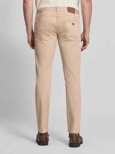 Männermodel trägt Slim Fit Jeans aus Baumwoll-Mix im 5-Pocket-Design von Emporio Armani in Beige, Ganzkörperansicht Rückansicht. Elastischer Stoff, sichtbare Nähte, Emporio Armani Patch am Bund, Bundweite 43 cm, Innenbeinlänge 82 cm.