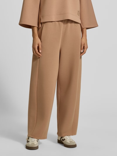 Kobiece modelka nosi Wide Leg Sweathose aus Modal-Mix model 'GETTO' od Weekend Max Mara, beżowy kolor, tekstura gładka, zbliżenie na dolną część ciała, widok z przodu.