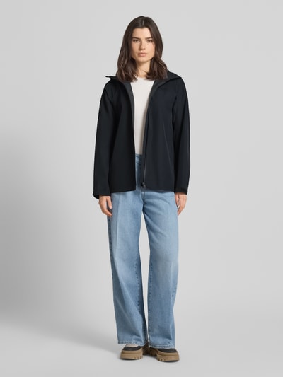 Frauenmodel trägt Regular Fit Jacke mit Logo-Print Modell 'Treeline' von PEAK PERFORMANCE in Schwarz, glatte Textur, Ganzkörperansicht von vorne, Rückenlänge bei Größe S 71 cm, Schulterbreite 44 cm, Brustweite 53 cm, Ärmellänge 55 cm.
