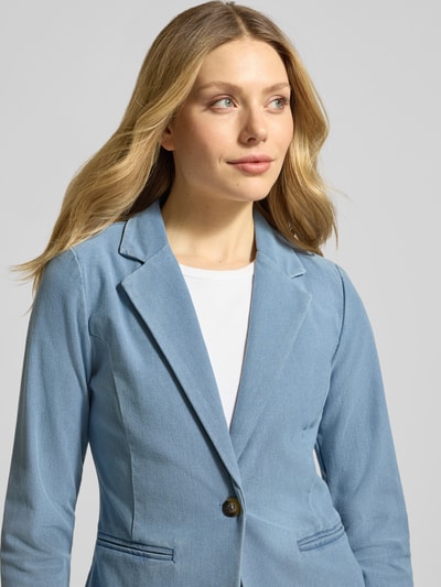 Frauenmodel trägt Regular Fit Blazer in Denim-Optik Modell 'Kate' von ICHI, hellblau, mit Paspeltaschen und Knopfverschluss, Nahaufnahme Oberkörper. Elastischer Baumwoll-Mix, taillierte Passform, 58 cm Rückenlänge, 43 cm Brustweite, 63 cm Ärmellänge.