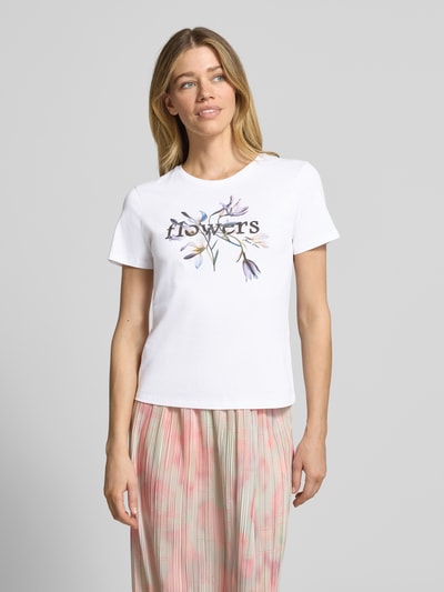 Frauenmodel trägt T-Shirt mit Strasssteinbesatz von Marc Cain in Weiß, reine Baumwolle, gerader Schnitt, Rundhalsausschnitt, Ganzkörperansicht von vorne.