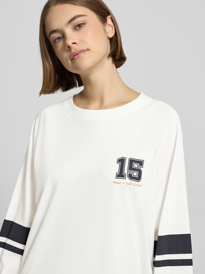 Kobiece modelka nosi Loose Fit Langarmshirt aus reiner Baumwolle od Marc O'Polo Denim, jednokolorowy, nadruk z motywem, paski w kontrastowym kolorze, okrągły dekolt, długie rękawy z prążkowanym wykończeniem, materiał: czysta bawełna, zbliżenie na górną część ciała.