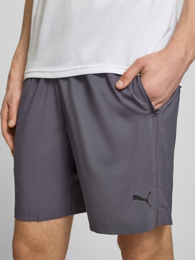 Männermodel trägt Shorts mit Logo und elastischem Bund von PUMA PERFORMANCE in Grau, Regular Fit, Nahaufnahme Oberkörper.