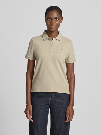 Frauenmodel trägt Poloshirt mit Logo-Stitching und Polokragen von Gant aus Reine Baumwolle im Regular-Fit, Knopfleiste, Ganzkörperansicht von vorne.