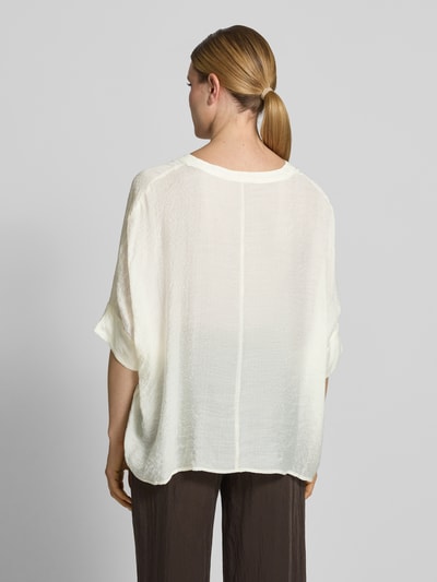 Modelka kobieca nosi Relaxed Fit Bluse aus Viskose-Mix mit 3/4-Arm von comma, kolor kremowy, faktura lekko marszczona, długość tyłu 62 cm, długość rękawów 18 cm, mieszanka wiskozy, krój relaxed fit, dekolt w serek, listwa guzikowa, rękaw o dł. 3/4, widok całej sylwetki z tyłu