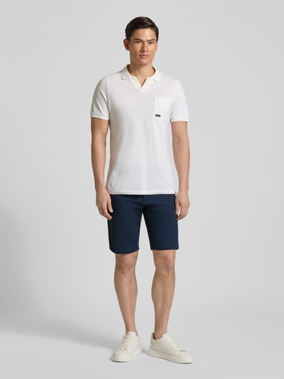 Męski model nosi Regular Fit Bermudas aus Baumwoll-Mix Modell 'PHOENIX' od s.Oliver RED LABEL, granatowy twill, widok całej sylwetki z przodu.