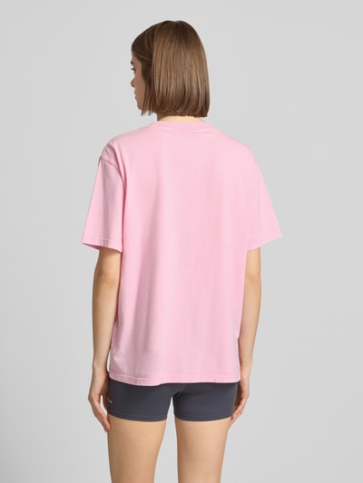 Frauenmodel trägt Relaxed Fit T-Shirt mit Logo-Print Modell 'Formation' von P.E Nation aus reiner Baumwolle in Rosa, Rundhalsausschnitt, Rückenlänge bei Größe S 65 cm, Ganzkörperansicht Rückansicht.