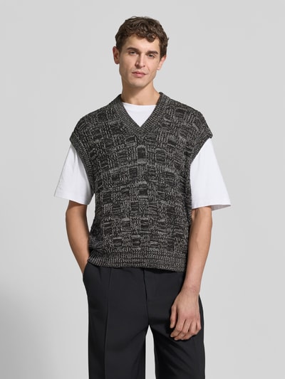 Mannelijk model draagt Regular Fit Pullunder uit katoen van Filippa K met V-hals, structuurpatroon, geribde boorden, zwart-wit tinten, volledig lichaam aan de voorkant.