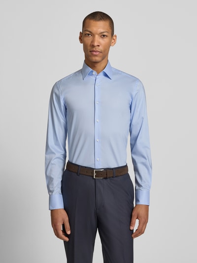 Męski model nosi Slim Fit Businesshemd aus reiner Baumwolle Modell 'HANK' von BOSS, efekt: jednolity kolor, popelina, kołnierzyk typu kent, listwa guzikowa na całej długości, naszywka z logo, zapięcie na guziki, długi rękaw, sportowy mankiet, zaokrąglone wykończenie dołu, widok całej sylwetki z przodu.