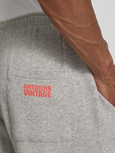 Männermodel trägt Sweatpants mit Eingrifftaschen Modell 'NYZZOW' von American Vintage aus Baumwoll-Elasthan-Mix in Grau, Detailaufnahme.