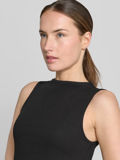 Frauenmodel trägt schwarzes Damen Midikleid mit U-Boot-Ausschnitt und Breite Träger Modell 'VALVIN' von Mango aus Baumwoll-Mix mit Stretch-Anteil, Nahaufnahme Oberkörper.