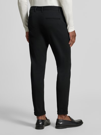 Männermodel trägt Slim Fit Stoffhose mit umgeschlagenen Hosenbeinen von Lindbergh, zwarte kleur, elastische materiaalmix met viscose, riemlussen, knoop- en ritssluiting, Bandwijdte maat M: 43 cm, Binnenbeenlengte maat M: 73 cm, Ganzkörperansicht Rückansicht.