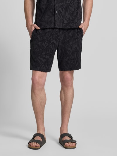 Männermodel trägt Regular Fit Sweatshorts aus reiner Baumwolle von Marc O'Polo, Optik:Allover-Muster, floral, Frottee, Nahaufnahme Oberschenkel.