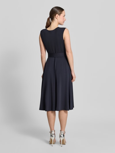 Modelka nosi Cocktailkleid mit Bindegürtel von Christian Berg Woman Selection, granatowy, elastyczny materiał, taliowany krój, długość midi, okrągły dekolt, drapowania, pasek, długość tyłu w rozmiarze 36: 105 cm, szerokość w rozmiarze 36: 33 cm, widok całej sylwetki z tyłu