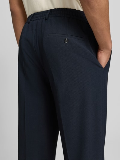 Männermodel trägt Stoffhose mit Bügelfalte Modell 'River' von JOOP! Collection aus dunkelblauem Material-Mix mit Viskose-Anteil, Detailaufnahme Rückansicht