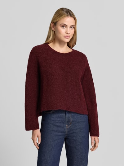 Frauenmodel trägt Strickpullover aus Alpaka-Leinen-Mix Modell 'VITOW' von American Vintage in Dunkelrot, lockere Passform, Nahaufnahme Oberkörper. Damen Strickpullover mit Rundhalsausschnitt, Stretch-Anteil, weiche Textur.
