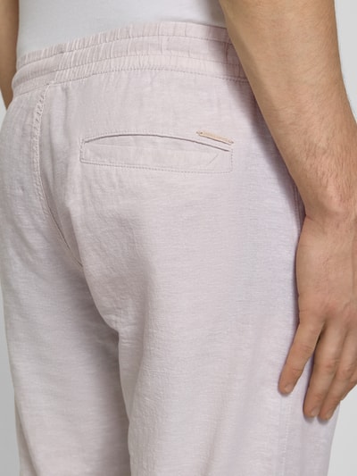 Mężczyzna nosi Hose aus Baumwoll-Leinen-Mix Modell 'KANE' od Jack & Jones, jasny kolor, krój regular fit, elastyczny pas, detal z tyłu, Szerokość w rozmiarze M: 41 cm, długość nogawki: 81 cm, zbliżenie na tylną część spodni
