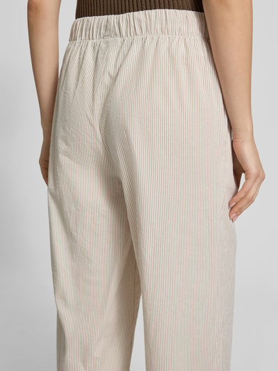 Frauenmodel trägt Loose Fit Weite Hose aus reiner Baumwolle Modell 'AUGUSTA' von Only, Optik: Allover-Muster, gestreift, Nahaufnahme Rückansicht.