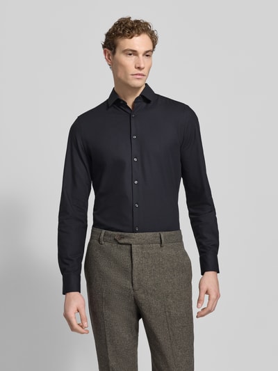 Männermodel trägt Slim Fit Businesshemd aus Baumwoll-Mix von OLYMP Level Five in Optik: Unifarben, Kentkragen, Ganzkörperansicht von vorne.