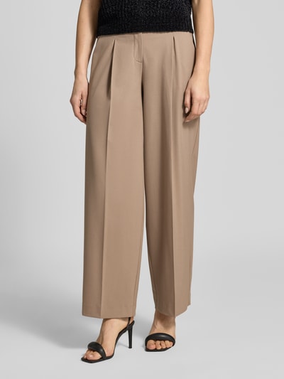 Frauenmodel trägt Stoffhose mit Gesäßtasche Modell 'Maiga' von Opus aus Material-Mix mit Viskose-Anteil, lockerem Schnitt, Bundfalten, französischen Eingrifftaschen, Knopf- und Reißverschluss, Bundweite bei Größe 36: 38 cm, Innenbeinlänge 77 cm, helle Beige-Töne, glatte Textur, Nahaufnahme Oberkörper.