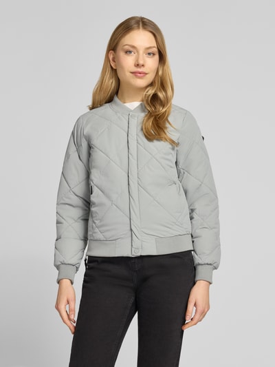 Modelka kobieca ma na sobie Steppjacke mit Knopfleiste Modell 'ANGE2' od khujo, jasnoszara, krój regular fit, faktura pikowana, stójka, szerokość w rozmiarze S 46 cm, długość tyłu 59 cm, długość rękawa 61 cm, szerokość ramion 36 cm, widok całej sylwetki z przodu