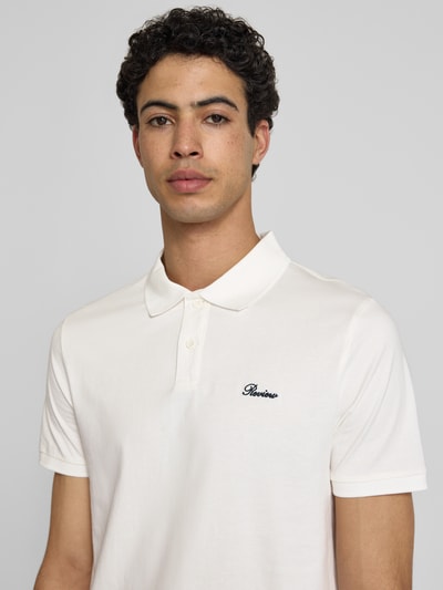 Männermodel trägt Slim Fit Poloshirt mit Label-Stitching von REVIEW in Weiß, Reine Baumwolle, Knopfleiste, Nahaufnahme Oberkörper.
