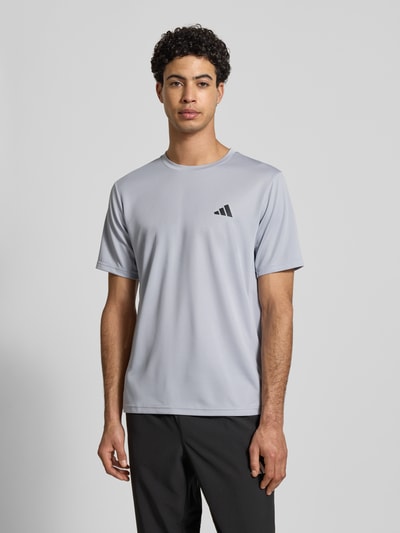 Męski model trägt Regular Fit T-Shirt mit Logo-Print von adidas Training, fakturowany wzór, okrągły dekolt, długość tyłu 70 cm, Ganzkörperansicht von vorne