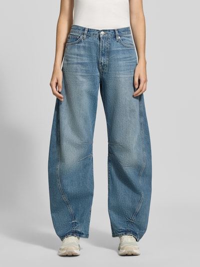 Frauenmodel trägt Wide Fit Jeans aus reiner Baumwolle Modell 'Sahar' von Samsøe Samsøe, blauer Denim, 5-Pocket-Design, Ganzkörperansicht von vorne.