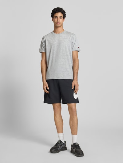 Mężczyzna model nosi T-Shirt mit Rundhalsausschnitt im 2er-Pack od CHAMPION, kolor szary, bawełna, krój regular fit, widok całej sylwetki z przodu.