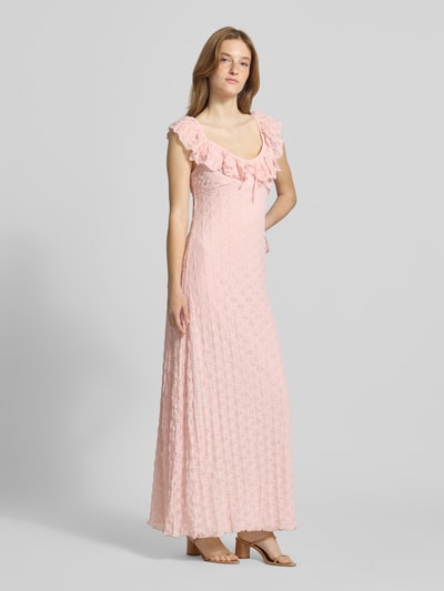 Frauenmodel trägt Midikleid mit Spitze und Schleifen-Detail von Gina Tricot in zartem Rosa, figurbetonter Schnitt, Volants, Material-Mix, Ganzkörperansicht von vorne.