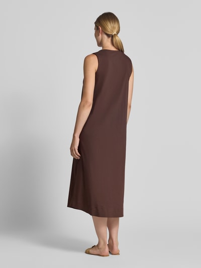 Frauenmodel trägt Midikleid mit V-Ausschnitt und Eingrifftaschen von MORE & MORE in Braun, ärmellos, A-Linie, Struktur glatt, Ganzkörperansicht Rückansicht. Baumwoll-Mix mit Stretch-Anteil, Rückenlänge 126 cm, Brustweite 50 cm.