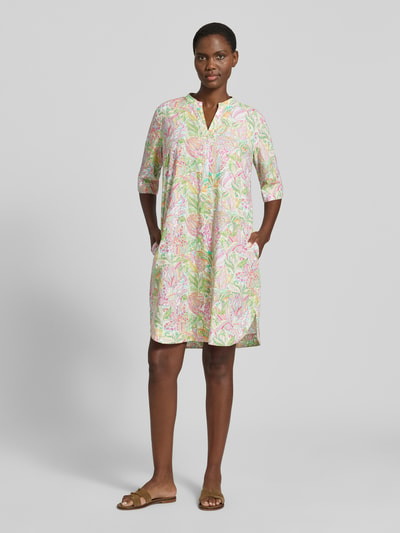 Frauenmodel trägt Knielanges Kleid im Allover-Look mit V-Ausschnitt von Emily Van den Bergh aus reiner Baumwolle, bunte Pastellfarben, gerader Schnitt, halbarm, Ganzkörperansicht von vorne.