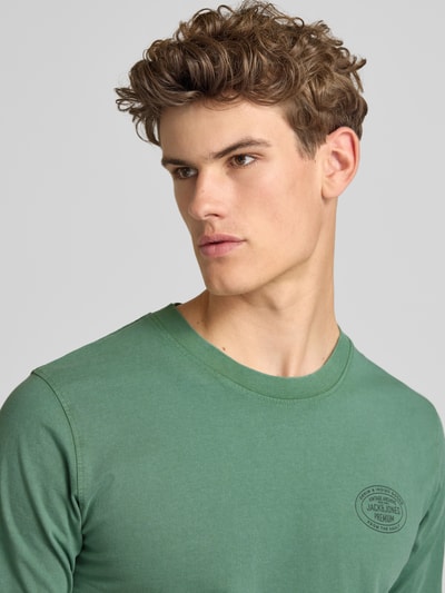 Männermodel trägt Herren T-Shirt von Jack & Jones Premium in Grün mit Label-Print Modell 'FELIX', Reine Baumwolle, Regular-Fit, Nahaufnahme Oberkörper.