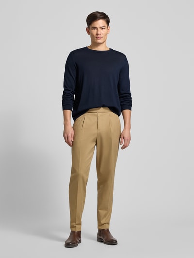 Männermodel trägt Longsleeve aus Schurwolle Modell 'Leno' von BOSS in melierter Optik, dunkelblau, elastische Abschlüsse, Ganzkörperansicht von vorne.