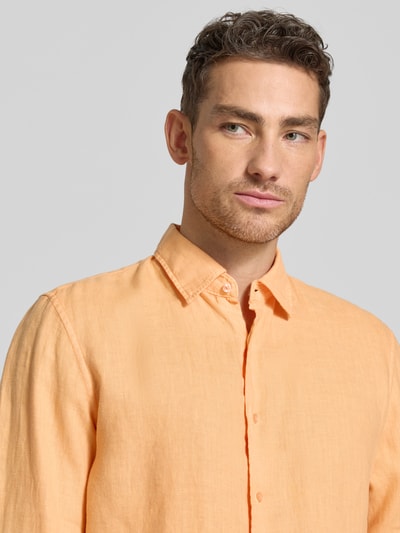 Mannelijk model draagt Leinenhemd mit Kentkragen van MCNEAL in oranje, regular fit, pure linnen, knoopsluiting, borst tot bovenarmen, close-up voorkant.