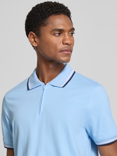 Männermodel trägt Slim Fit Poloshirt mit Kontraststreifen und Reißverschluss von MCNEAL aus Baumwoll-Elasthan-Mix, Nahaufnahme Oberkörper.