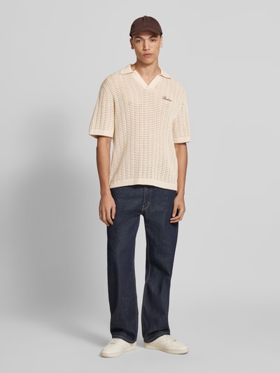 Mannenmodel draagt Slim Fit Poloshirt in Crochet-Optik van REVIEW, crème, katoen, polokraag, logo-stiksel, half mouw, vooraanzicht.