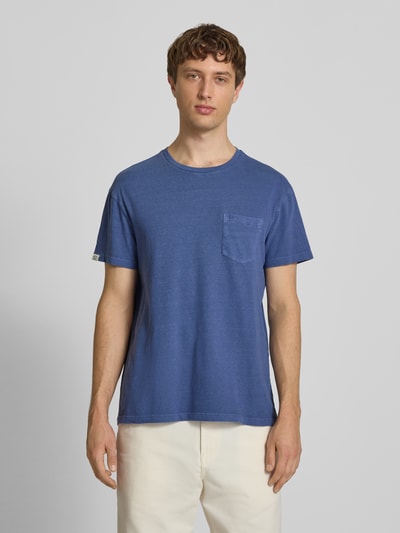 Männermodel trägt T-Shirt aus Baumwoll-Leinen-Mix mit Brusttasche von Superdry in Blau, Regular-Fit, Rundhalsausschnitt, Herren T-Shirt, Rückenlänge bei Größe M 66 cm, Ganzkörperansicht von vorne.