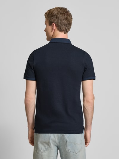 Männermodel trägt Slim Fit Poloshirt mit Viskose-Anteil Modell 'Paulos' von JACK & JONES in Dunkelblau, Baumwoll-Viskose-Mix, Logo-Stitching, Rückenlänge bei Größe M 72 cm, Kurzärmeliges Design, Ganzkörperansicht Rückansicht.