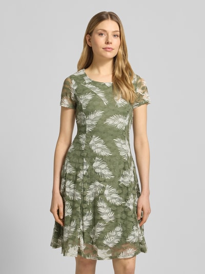 Frauenmodel trägt Knielanges Kleid mit Rundhalsausschnitt von Apricot in Grün mit weißem Blattmuster, Material-Mix mit Stretch-Anteil, A-Linie, blickdichtes Unterkleid, Ganzkörperansicht von vorne. Rückenlänge bei Größe S: 93 cm, Brustweite: 41 cm, Ärmellänge: 17 cm.