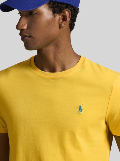 Männermodel trägt Regular Fit T-Shirt aus reiner Baumwolle von Polo Ralph Lauren in Uni-Gelb mit Logo-Stitching, Nahaufnahme Oberkörper.