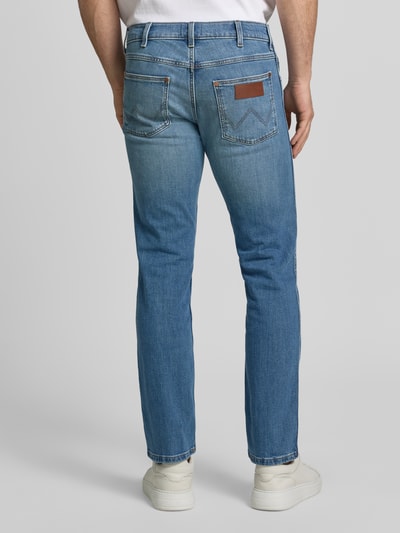 Männermodel trägt Jeans im Used-Look Modell 'Greensboro' van Wrangler, mix van katoen en elastaan, slim fit, steekzakken, ganzkörperansicht rückansicht. Context: heren jeans, bandwijdte maat 32/32 42 cm, binnenbeenlengte 77 cm.
