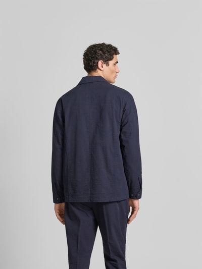 Männermodel trägt Relaxed Fit Hemdjacke aus Baumwolle von Officine Générale in Dunkelblau, strukturierte Oberfläche, Ganzkörperansicht Rückansicht.