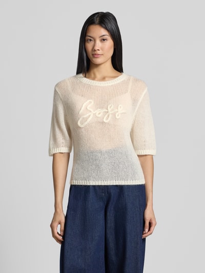 Frauenmodel trägt cremefarbenen, halbtransparenten Regular Fit Pullover aus Schurwoll-Modal-Mix Modell 'C_Farezza' von BOSS Orange, lockere Strickstruktur, Ganzkörperansicht von vorne.
