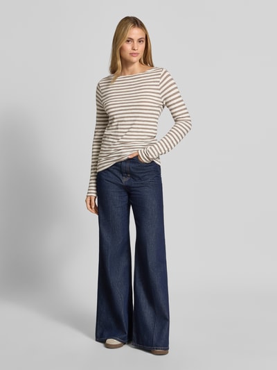 Frauenmodel trägt Regular Fit Langarmshirt aus reiner Baumwolle von Marc O'Polo, beige-weiß gestreift, kombiniert mit blauer Jeans, Ganzkörperansicht von vorne, Damen Langarmshirt von Marc O'Polo.
