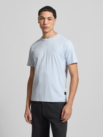 Männermodel trägt Regular Fit T-Shirt mit Logo-Detail von Replay in hellblau aus reiner Baumwolle, Rundhalsausschnitt, Ganzkörperansicht von vorne.
