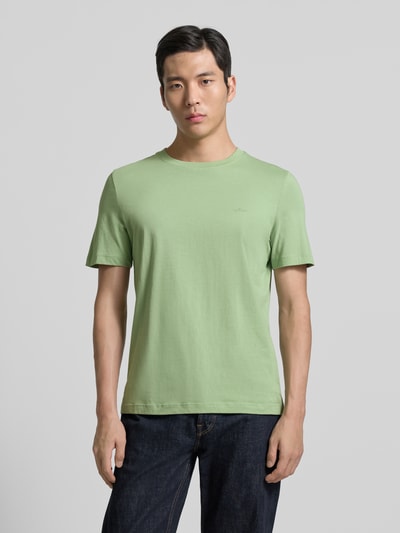 Männermodel trägt Regular Fit T-Shirt aus reiner Baumwolle von s.Oliver RED LABEL in Unifarbe, Jersey, Label-Schriftzug, Ganzkörperansicht von vorne.