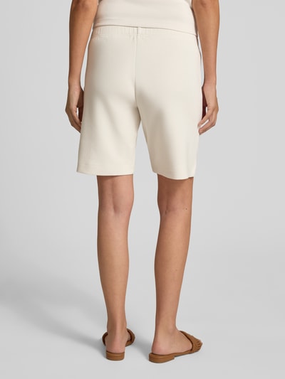 Vrouwenmodel draagt Regular Fit Shorts met elastische band van Christian Berg Woman in lichte kleur, elastische materiaalmix, ziernaden. Volledige lichaamsweergave achterkant.