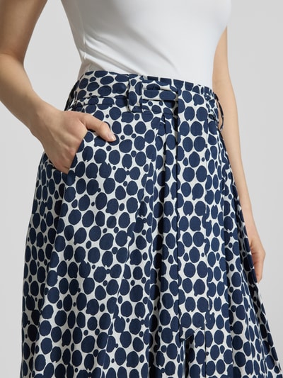 Kobiece model prezentuje Spódnica midi im Allover-Look mit elastischem Bund od More & More, mieszanka bawełny i elastanu, linia A, wzór na całej powierzchni, elastyczny pas, szerokość w rozmiarze 36: 40 cm, całkowita długość w rozmiarze 36: 89 cm, granatowe kropki na białym tle, tekstura gładka, zbliżenie na górną część spódnicy, detal pasa i kieszeni, z przodu.